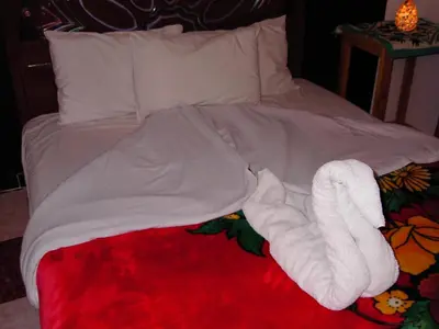 a bed with a white towel animal laying on it at Sphinx in Al Karnak