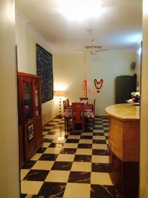 a living room with a checkered floor and a kitchen at Sphinx in Al Karnak