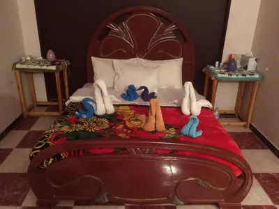 a bed with a wooden head board with stuffed animals on it at Sphinx in Al Karnak