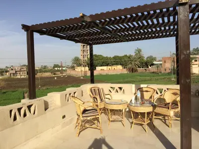 a group of chairs and a table on a patio at Yuhan's Bed & Breakfast in Al Karnak