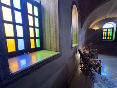 a room with a window with chairs and a table at Yuhan's Bed & Breakfast in Al Karnak