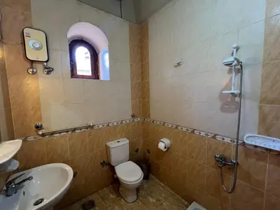 a bathroom with a toilet and a sink and a shower at Yuhan's Bed & Breakfast in Al Karnak