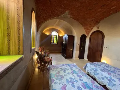 a bedroom with two beds and a window in a building at Yuhan's Bed & Breakfast in Al Karnak
