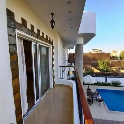 a balcony of a house with a swimming pool at Entire Oasis Villa - Heart of Ancient Luxor in Luxor