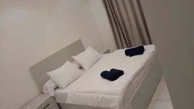 a white bed with blue pillows on it at Luxury Panorama Sea View Residence with sky pool in Hurghada