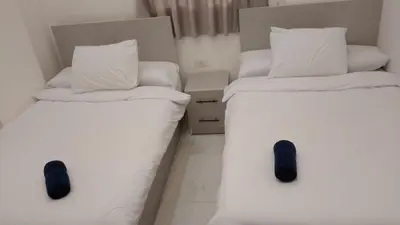 two beds with white sheets and black shoes on them at Luxury Panorama Sea View Residence with sky pool in Hurghada
