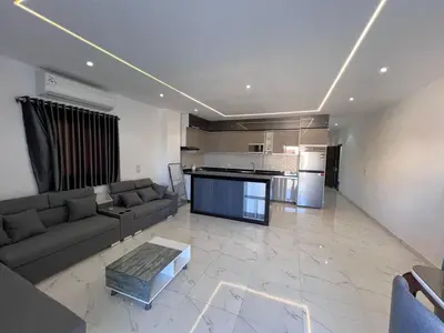 a living room with a couch and a kitchen at Luxury Panorama Sea View Residence with sky pool in Hurghada