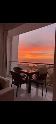 a living room with a table and a view of a sunset at Luxury Panorama Sea View Residence with sky pool in Hurghada