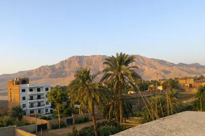 a view of a city with palm trees and mountains at Astralis Hotel - Hot Air Balloon View in Al Aqālitah