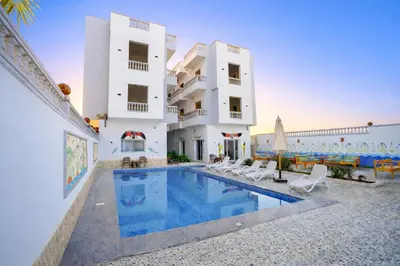 a house with a swimming pool in front of a building at Astralis Hotel - Hot Air Balloon View in Al Aqālitah
