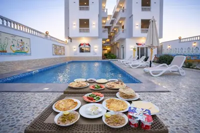 a buffet of food on a table next to a swimming pool at Astralis Hotel - Hot Air Balloon View in Al Aqālitah