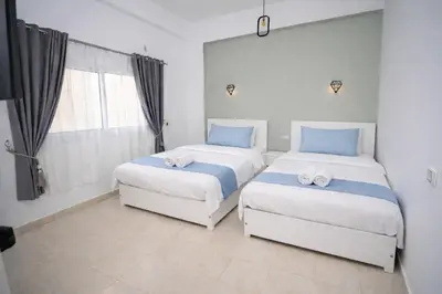 a bedroom with two beds and a window at Astralis Hotel - Hot Air Balloon View in Al Aqālitah