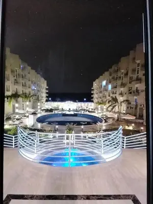 a large swimming pool at night with buildings in the background at Hurghada Pool & See View Studio in Hurghada