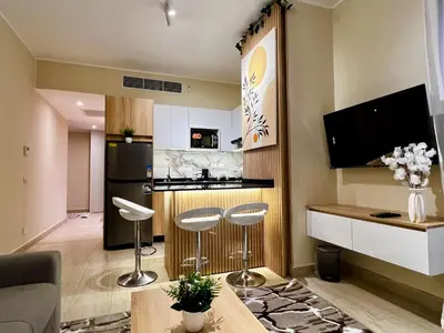 a living room with two bar stools and a kitchen at ALDAU village mall in Hurghada