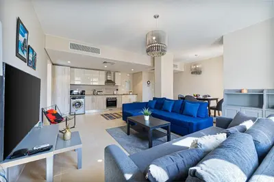 a living room with a blue couch and a kitchen at Serenity Pool View Holiday Home in Hurghada