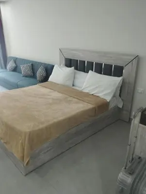 a bedroom with a large bed and a blue couch at scandic Beach Hurghada in Hurghada