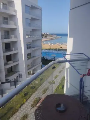 a balcony with a view of a building and the ocean at scandic Beach Hurghada in Hurghada