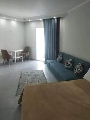 a living room with a blue couch and a table at scandic Beach Hurghada in Hurghada