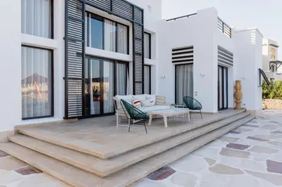 a patio with a table and chairs on it at The Reef House Luxury Waterfront Villa in Hurghada