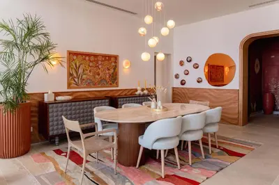 a dining room with a wooden table and white chairs at The Reef House Luxury Waterfront Villa in Hurghada