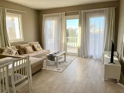 a living room with a couch and a table at Cozy 1-bedroom Joubal lagoon apartment in Hurghada