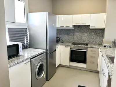 a kitchen with a refrigerator and a washing machine at Cozy 1-bedroom Joubal lagoon apartment in Hurghada
