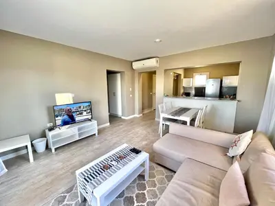 a living room with a couch and a flat screen tv at Cozy 1-bedroom Joubal lagoon apartment in Hurghada