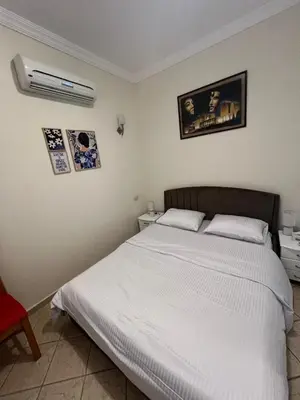 a bedroom with a white bed and a red chair at green garden resort in Hurghada