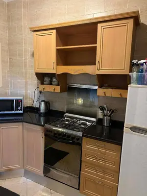 a kitchen with wooden cabinets and a stove top oven at green garden resort in Hurghada