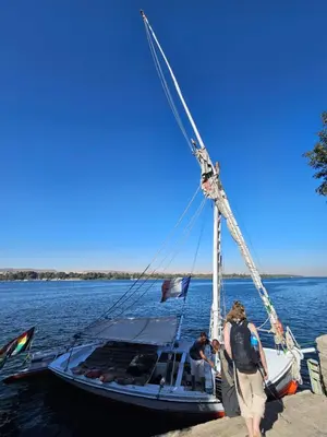 a group of people standing on a boat in the water at Aswan all-inclusive private felucca in Aswan