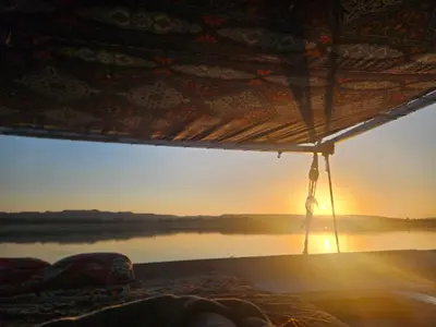 a view of a sunset from the inside of a tent at Aswan all-inclusive private felucca in Aswan
