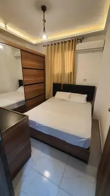 a bedroom with two beds and a dresser at La Luna Garden Magawish in Hurghada