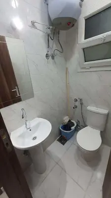 a white bathroom with a toilet and a sink at La Luna Garden Magawish in Hurghada