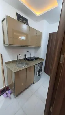 a kitchen with a sink and a washing machine at La Luna Garden Magawish in Hurghada