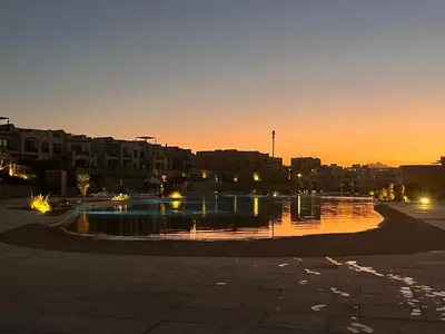 a pool of water in a parking lot at sunset at 1BR Chalet at Makadi Heights Hurghada in Hurghada