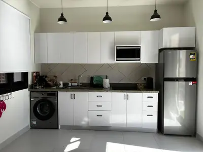 a kitchen with white cabinets and a black refrigerator at 1BR Chalet at Makadi Heights Hurghada in Hurghada