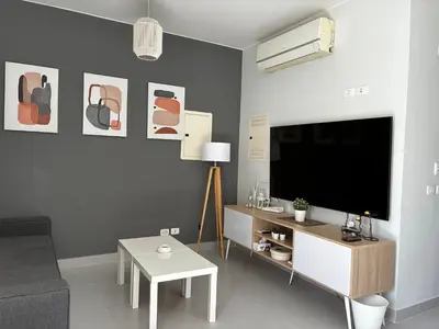a living room with a tv and a couch and a table at 1BR Chalet at Makadi Heights Hurghada in Hurghada