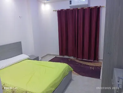 a bedroom with a bed and a red curtain at Red Ruby chalets &flats HRG,Elgouna in Hurghada