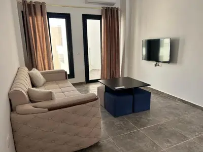 a living room with a couch and a table and a tv at Aqua infinity resort in Hurghada