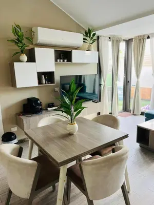 a dining room table with chairs and a television at Bali chalet with private heated pool in Hurghada