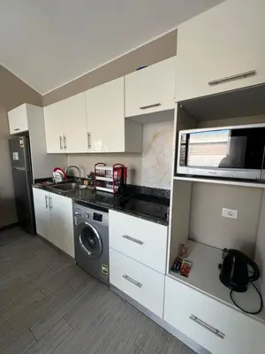 a kitchen with white cabinets and a washing machine at Bali chalet with private heated pool in Hurghada