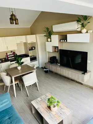 a living room with a table and a large television at Bali chalet with private heated pool in Hurghada