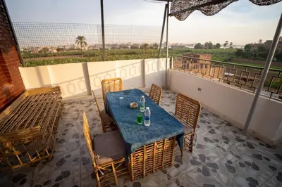 a table and chairs on a balcony with a view at Queen of Merit in Luxor