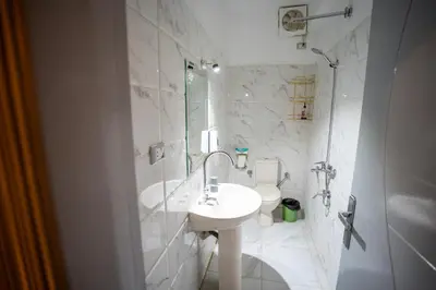 a white bathroom with a sink and a toilet at Queen of Merit in Luxor