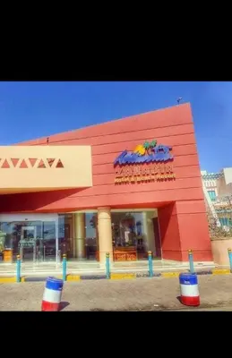 a red building with a sign on the side of it at قريه الدهبيه in Hurghada