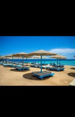 a group of umbrellas on a beach with the ocean at قريه الدهبيه in Hurghada