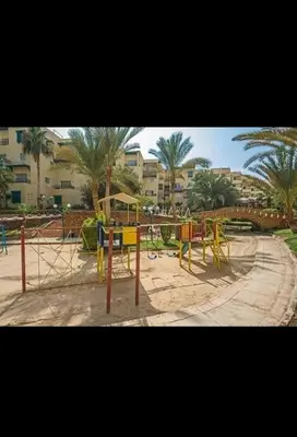 a playground with tables and chairs and palm trees at قريه الدهبيه in Hurghada