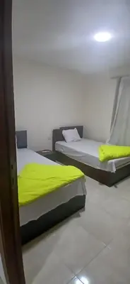 two beds with yellow sheets in a room at Hurghada Tiba Golden Beach Resort Down Town in Hurghada