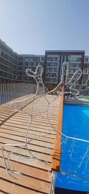 a wooden deck with chairs on top of a swimming pool at Hurghada Tiba Golden Beach Resort Down Town in Hurghada