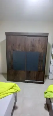 a large wooden cabinet in a room with a bed at Hurghada Tiba Golden Beach Resort Down Town in Hurghada